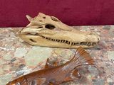 a fish statue on a table next to a piece of driftwood