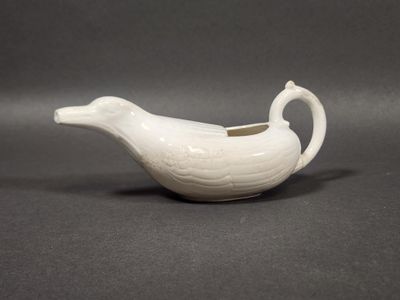 une soucoupe en porcelaine blanche en forme de canard, munie d'une anse