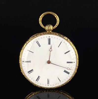 a gold pocket watch with roman numerals on the face