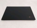a black laptop on a white surface with a red x on the screen