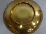 a gold plate that is sitting on a white table