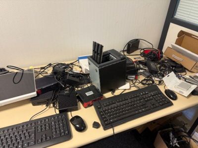 un bureau sur lequel se trouvent un ordinateur, un clavier, une souris et d'autres appareils électroniques