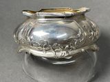 a silver pot with a spoon on top of it