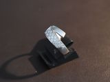 a diamond ring sitting on top of a piece of leather