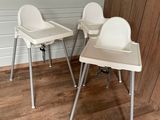 une paire de chaises hautes blanches dans une pièce avec un parquet