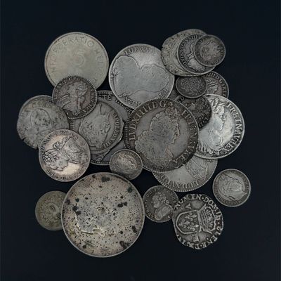 un tas de pièces d'argent posé sur une surface noire