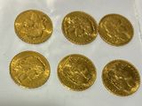 a close up of a bunch of gold coins on a white surface
