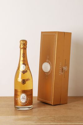 des bouteilles de champagne posées sur une table en bois à côté d'une boîte