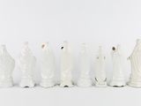 a group of white figurines that are lined up together