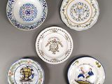 quatre assiettes ornées de motifs différents, posées sur un fond gris