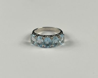 un gros plan d'une bague en argent sertie de pierres bleues