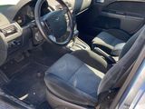 the interior of a car with the door open and the driver ' s seat down