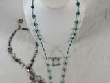 necklaces and bracelets on a mannequin stand on a white surface