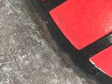 a close up of a red and black skateboard on the ground