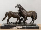 a statue of two horses and a dog on a table