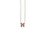 a gold necklace with a letter h on a chain
