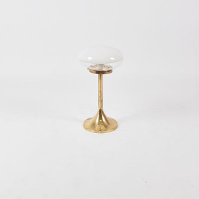 a brass and glass table lamp on a white background