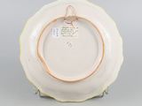 a white plate with a gold rim sitting on a stand
