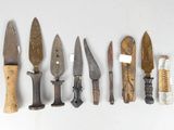several different types of knives are lined up on a white surface