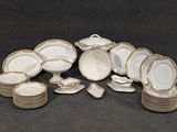 une pile d'assiettes et de bols en porcelaine blanche et dorée