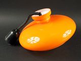 un objet orange posé sur une surface noire
