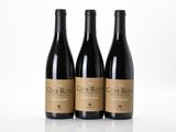 three bottles of wine sitting on top of a white table
