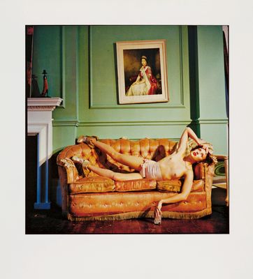 a woman laying on a couch in a green room