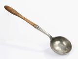 an old spoon with a wooden handle on a white surface