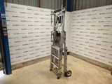 an image of a metal hand truck in a warehouse with a sign on the wall behind it