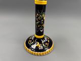 une image représentant un vase noir et jaune posé sur une table
