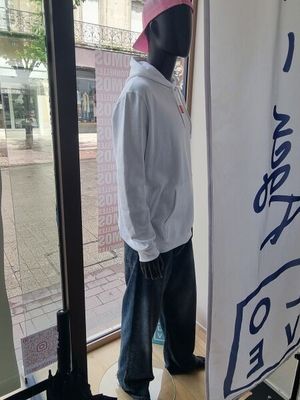 a mannequin wearing a pink hat in a store window