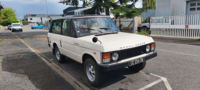 un Land Rover blanc garé sur le bord de la route