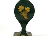 a green lamp that has a gold leaf design on it