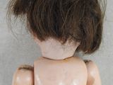 a close up of a doll with a very short hair