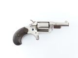 gros plan d'un revolver sur une surface blanche