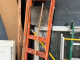 a ladder with a broom on top of it next to a stack of buckets