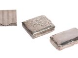 trois pièces métalliques argentées posées sur une surface blanche, sur fond blanc