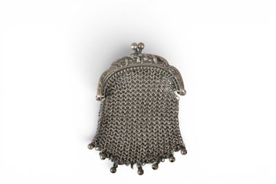 an old silver purse with a chain around it on a white surface