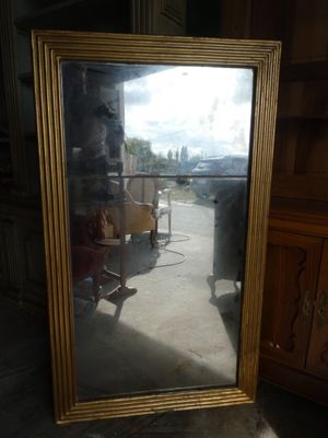 a mirror that is sitting on the floor in front of a dresser