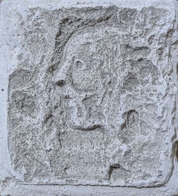 an image of a close up of a stone block with a face carved into it
