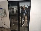 quelqu'un en train de prendre une photo de son reflet dans la porte vitrée d'un réfrigérateur