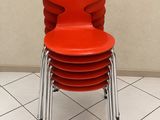 une pile de chaises rouges posées sur un sol carrelé