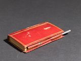 a small red book with a cigarette sticking out of it