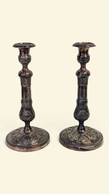 pair of antique brass candlesticks on a white background