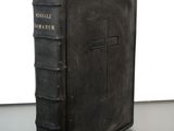 an old book with a cross on it sitting on a table