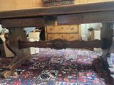 a large wooden table on a rug on the floor