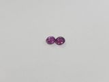 a pair of purple sapphires on a white surface