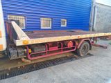 a flat bed truck parked in front of a blue building