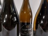 several bottles of wine are lined up on a white surface