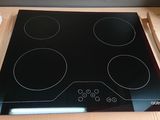 a black stove top with four burners on it